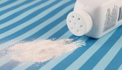 How to Get Rid of Razor Bumps: baby powder container and spilled baby powder