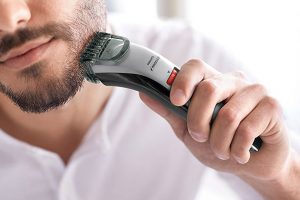 man shaving with electric shaver vs razor