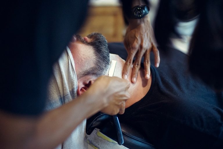 barber shaping the beard of his customer