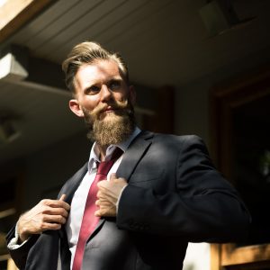 man looking to the side while holding his coat