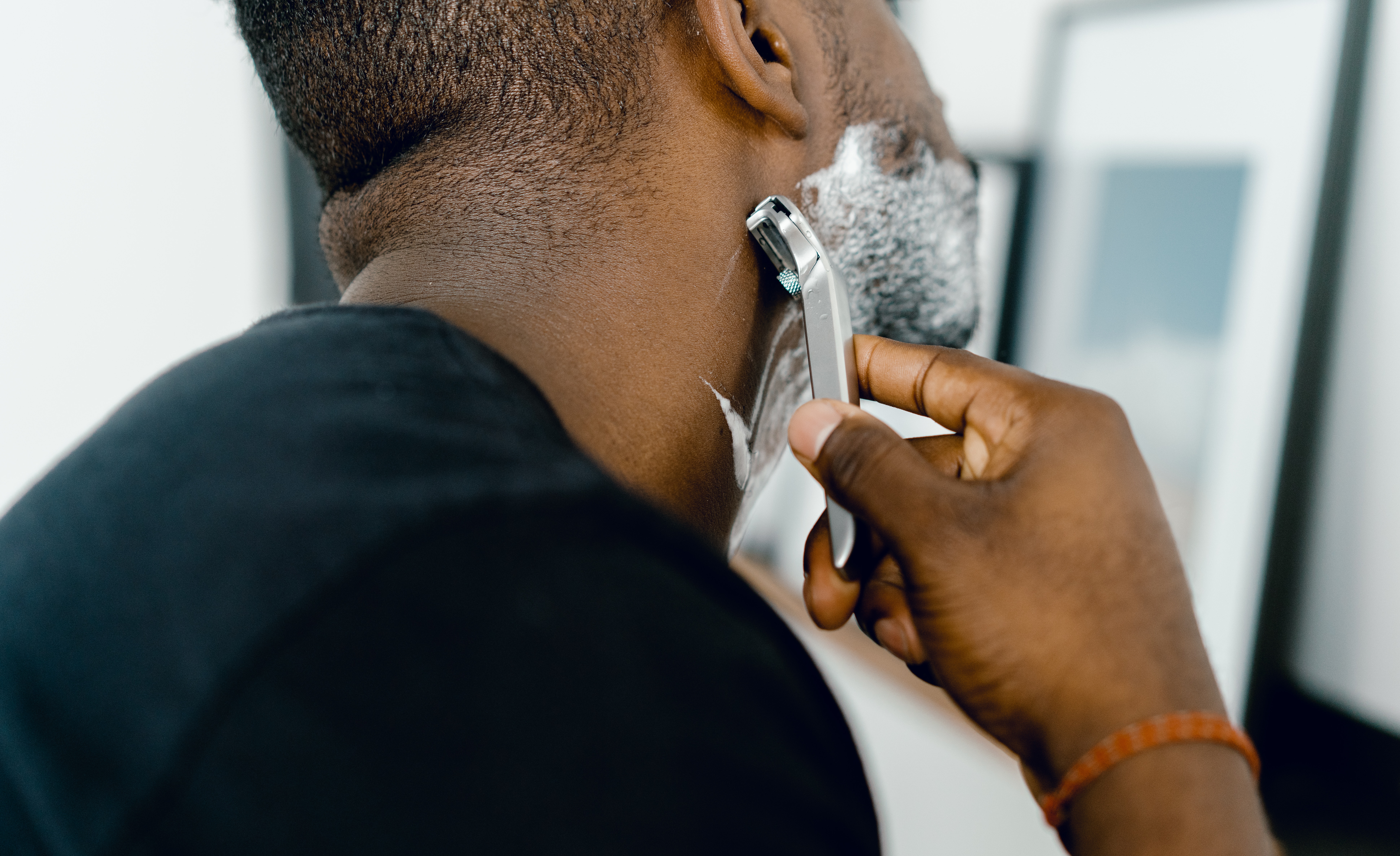 man learning how to use an electric shaver