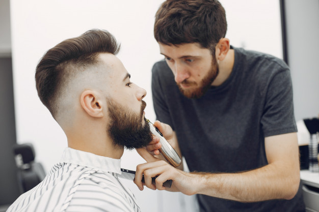 stylish man having his beard shaved