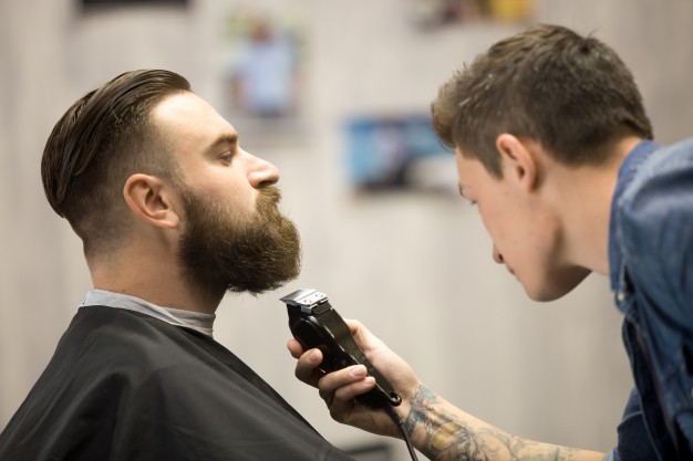 young man getting beard grooming